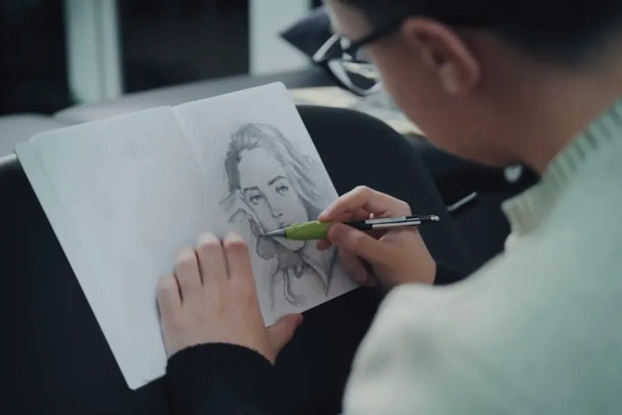 Eine Artist zeichnet ein Porträt in ihr Skizzenbuch
